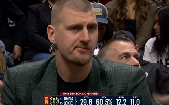 开云全站-挺淡定！约基奇场边便装观战 嘴里嚼着东西